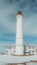 Vertical low angle shot of a white lighthouse under the cloudy sky Royalty Free Stock Photo