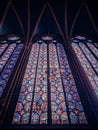 Vertical low angle show of bright colorful stained glass windows in a church