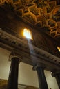 Vertical low angle of the sun rays coming through a small window of a church in Rome, Italy Royalty Free Stock Photo