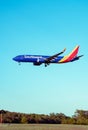 Vertical low angle view of a blue china southwest airplane in flight on a background of blue sky
