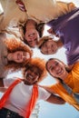 Vertical low angle view of five teenage girls laughing and looking at camera. Group of young women smiling looking down Royalty Free Stock Photo