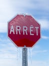 Vertical low angle view of French stop sign encased in ice after ice storm Royalty Free Stock Photo