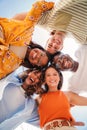 Vertical. Low angle view of a group of five multiracial teenagers smiling and looking down at camera outdoors. Young Royalty Free Stock Photo