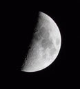 Vertical macro shot of a half-moon with the detailed surface in a clear dark sky Royalty Free Stock Photo
