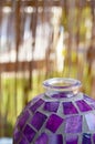 Vertical macro shot of an old purple mosaic vase