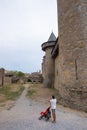 Vertical of a man with baby stroller against the Carcassonne medieval citadel in the south of France