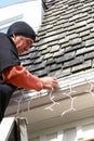 Vertical man on ladder hanging Christmas lights Royalty Free Stock Photo