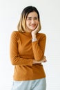 Vertical medium shot portrait of a cute smiling Asian woman with golden short straight hair in a casual long sleeve brown clothes