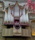 Vertical metallic pipe organ mounted on the wall