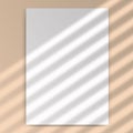 Vertical mock up of empty paper blank. Reflected blinds shadow from window. Realistic silhouette effect background