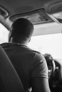 Vertical monochrome shot of a man driving a car