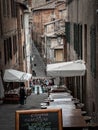 Vertical of a narrow Italian street with a group of elderly people gathered together