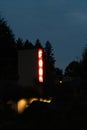 vertical neon sign glowing in the dark late at night Royalty Free Stock Photo