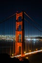 Vertical night shot of the Golden Gate bridge with decorative lights and skyline in the background Royalty Free Stock Photo