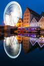 Vertical night view for Ferris wheel with water reflection