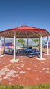 Vertical Octagon shaped picnic pavilion with view of colorful playground and scenic lake Royalty Free Stock Photo