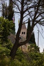 Vertical of an old church tower seen behind green trees on a sunny day in Split, Croatia Royalty Free Stock Photo