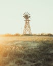 Vertical of an old windmill in a field at sunset in Texas Royalty Free Stock Photo