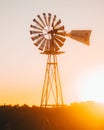Vertical of an old windmill in a field at sunset in Texas Royalty Free Stock Photo