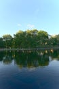 A vertical orientation of reflections of trees and clouds on lake water, La Fontaine Park, Montreal, QC, Canada Royalty Free Stock Photo