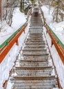 Vertical Outdoor stairway with grated metal treads in a snowy mountain town in winter