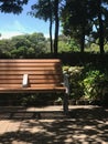 Vertical outdoor wooden garden bench and tree in park