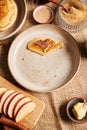 Vertical overhead shot of a half eaten pancake with apples sugar and other ingredients on the side