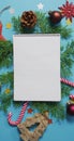 Vertical overhead shot of a notebook surrounded by Christmas decorations on a blue background Royalty Free Stock Photo