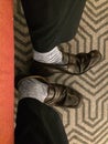 Vertical overhead shot of a person`s feet wearing white socks and brown moccasins