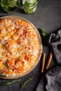 Vertical overhead shot of a pizza on a black table with mojitos and cinnamon on the side