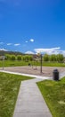 Vertical Park in the middle of a lush grassy field under vast blue sky with clouds