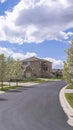 Vertical Paved road lined with white flowering trees on a scenic neighborhhod