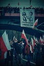 Vertical of people marching with Polish flags and political banner on the Independence day of Poland