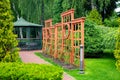 Vertical pergola made of wood in a rose garden with a stone tile walkway. Royalty Free Stock Photo