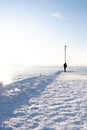 Vertical of a person walking on a snow-covered path in Tjuvholmen, Oslo Norway Royalty Free Stock Photo