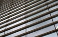 Vertical perspective view of the facade of a modern glass commercial building with steel frames and sky reflected in the windows Royalty Free Stock Photo