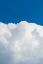 Vertical photo of beautiful dense white clouds at the bottom of the frame. Blue sky at the top of the frame