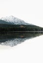 Vertical photo of beautiful lake in autumn scenery with amazing snowy mountains on background. Strbske pleso in High Tatras in Royalty Free Stock Photo