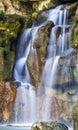 Vertical photo of beautiful waterfall in park with green moss on Royalty Free Stock Photo