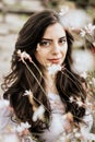 Vertical photo of beautiful young woman surrounded by flowers outdoor Royalty Free Stock Photo