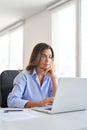 Busy mature business woman using laptop computer working in office. Vertical. Royalty Free Stock Photo