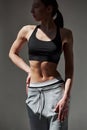 Vertical photo. Caucasian pretty woman stands against wall in the studio at daytime