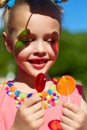 Girl smiles and looks at transparent multi-colored lollipops Royalty Free Stock Photo