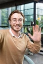 Vertical photo. Close-up photo. Young man freelancer, blogger greets and talks to the camera, smiles, waves, records Royalty Free Stock Photo