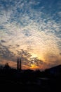 Vertical photo of the dawn over city. The sun rises through the clouds with a fiery disk