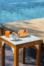 Vertical photo of delicious breakfast with swimming pool background Royalty Free Stock Photo