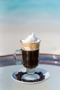 Vertical photo of the freshly made black coffee cocktail on the glass table at the beach with ocean Royalty Free Stock Photo