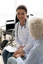 Friendly doctor supporting disabled patient during visit, holding hand Royalty Free Stock Photo