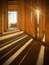 Sunlight peeking between wood studs inside a new home under construction