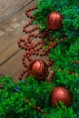 Vertical photo of green branches with berries abundantly decorated with toys to decorate the Christmas tree on a wooden table Royalty Free Stock Photo